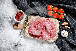 Slices of spanish salami salchichon. Gray background. Top view