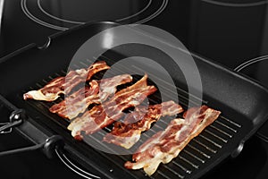 Slices of tasty fried bacon in grill pan