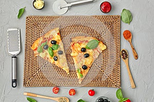 Slices of tasty Italian pizza and ingredients on table