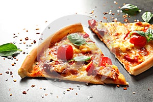 Slices of tasty pizza with tomatoes and sausage s on table