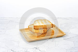 Slices toast bread in wooden dish on table.