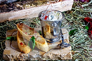 Slices of toast with sour cream and herbs on a wooden board