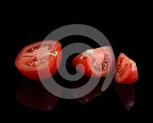 Slices of tomatoes on a black background, ripe vegetables for salad