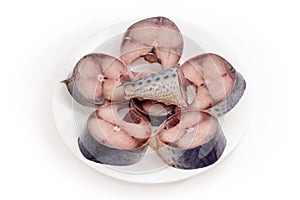 Slices of uncooked thawed chub mackerel on a white dish