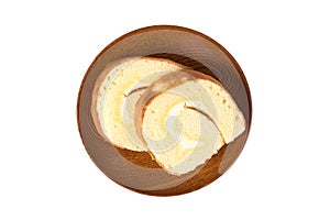 Slices of vanilla roll cake in wooden plate on white background