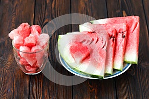 Slices of watermelon on plate and glass with heartshape