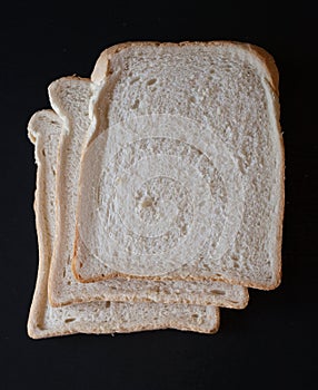 Slices of white bread on a black background photo