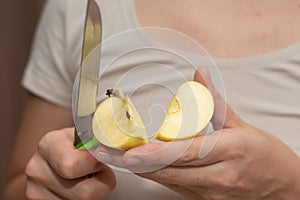 Slicing an Apple with Knife. Cutting a ripe apple in half with a kitchen knife
