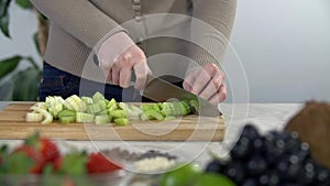 Slicing celery on wooden cooking desk