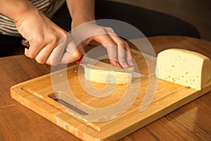 Slicing cheese with a knife on the board