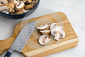 Slicing Cremini Mushrooms on a Wood Cutting Board