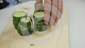 Slicing cucumber for lettuce. Cutting vegetables on wooden kitchen board.