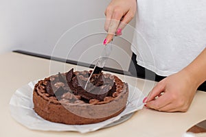 Slicing a Decadent Chocolate Cake on Table