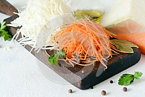 Slicing Fresh cabbage and carrots on a wooden board on a light background. Vegetables for ferment, for long fermentation.