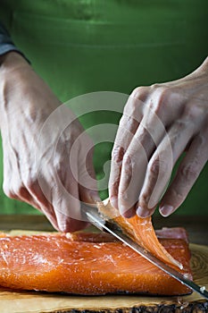 Slicing gravlax salmon with a knife photo