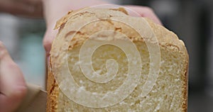 Slicing homemade bread loaf with serrated knife. Home cooking and baking concept