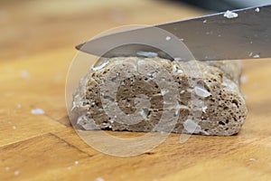 Slicing homemade seitan on wooden board