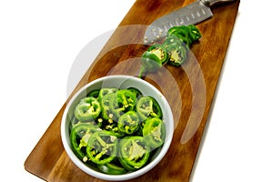 Slicing JalapeÃ±o peppers on a wooden cutting board