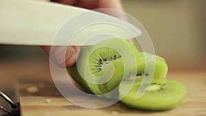 Slicing a kiwi. Close-up man hand with knife