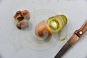 Slicing kiwi fruit with a knife on a board