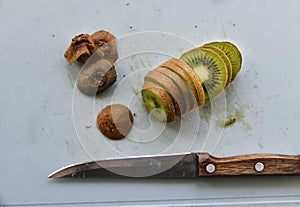 Slicing kiwi fruit with a knife on a board
