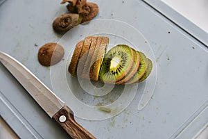 Slicing kiwi fruit with a knife on a board