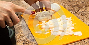 Slicing onions with a knife on the board