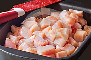 Slicing pieces of diced chicken breast