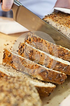 Slicing Rustic Wholemeal Seeded Loaf of Bread