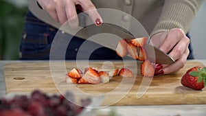 Slicing the strawberry on a wooden desk