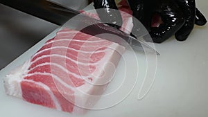 Slicing tuna with a knife and laying seafood slices.