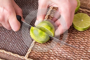 Slicing zested lime with knife.