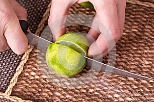 Slicing zested lime with knife.