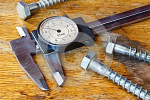 Slide caliper with a round dial on the table in workshop