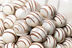 Slide of chocolates covered with white chocolate and lines from brown close-up