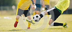 Slide Tackle in Soccer Match. Two Young Soccer Players in a Duel Compete For Ball. Teenage Players Playing Football Game