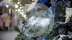 Slider view of blue mirror and matte balls and snow. New Year`s and abstract blurred shopping mall background with