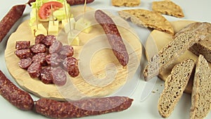 Slider view of chefs hands serving a typical South Tyrolean snack plate like Tyrolean smoked sausage on a wooden cutting board