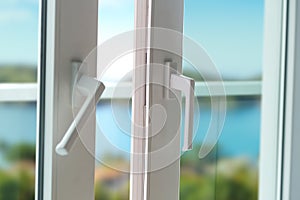 Sliding door of a balcony. Close-up of the lock on the door with and nice landscape of background.