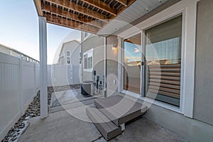 Sliding glass door and wooden steps at the back of a home with wooden fence