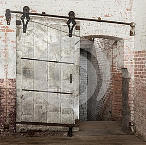 Sliding heavy industrial metal door in old warehouse