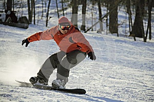 Sliding snowboarder on flank of hill