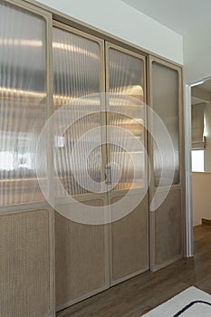 Sliding wooding doors of modern wardrobe in a hallway of a house.