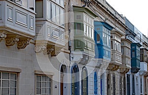 SLIEMA, MALTA - OCTOBER 26TH 2019: Traditional multicoloured wooden balcony windows overlook the road in the back streets of Malta