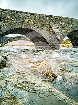 Sligachan Old stone Bridge over River Sligachan with Beinn Dearg Mhor and Marsco peak of Red Cuillin mountains in