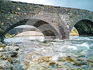 Sligachan Old stone Bridge over River Sligachan with Beinn Dearg Mhor and Marsco peak of Red Cuillin mountains in