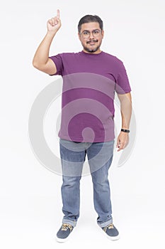 A slightly chubby guy pointing to something up in the air. Guiding and looking at the camera. Wearing a purple waffle shirt and