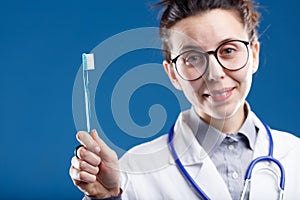 Slightly defocused dentist showing a toothbrush