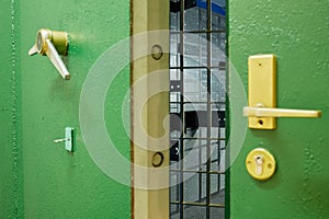 Slightly open heavy door with lever locks, photo