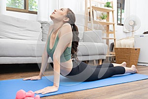 Slim Asian woman doing yoga meditation at home